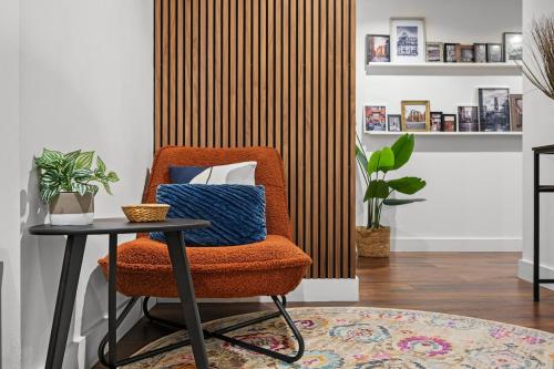 a room with a chair and a table at One Cambridge Residence by COQOON in Manchester