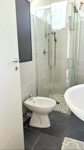 a bathroom with a toilet and a shower and a sink at POMPEI VESEVUS APARTAMENT in Boscotrecase