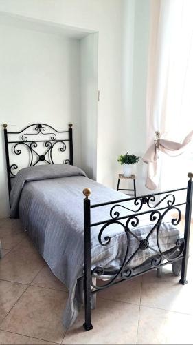 a black bed in a bedroom with a window at POMPEI VESEVUS APARTAMENT in Boscotrecase