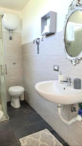 a bathroom with a sink and a toilet and a mirror at POMPEI VESEVUS APARTAMENT in Boscotrecase