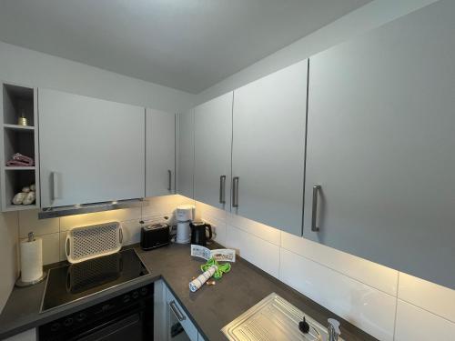 una cucina con mobili bianchi e un lavandino di Haus Weitblick Emil a Flensburgo