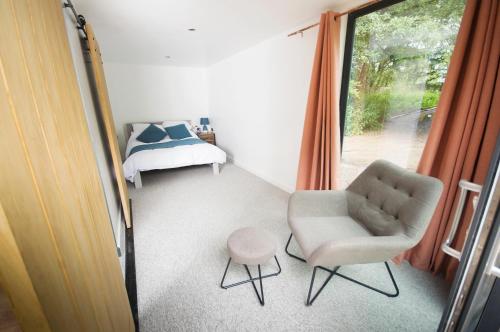 a bedroom with a chair and a bed and a window at Bird Nest - dine with the eagles Private Retreat in Carlisle