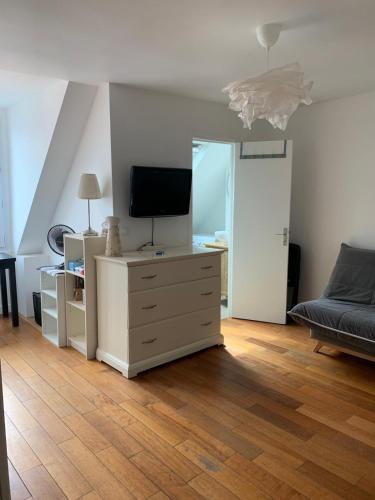 une chambre avec une commode sur laquelle se trouve une télévision dans l'établissement Studio Saint-Germain-des-prés, à Paris