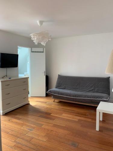 - une chambre avec un lit, une commode et une télévision dans l'établissement Studio Saint-Germain-des-prés, à Paris