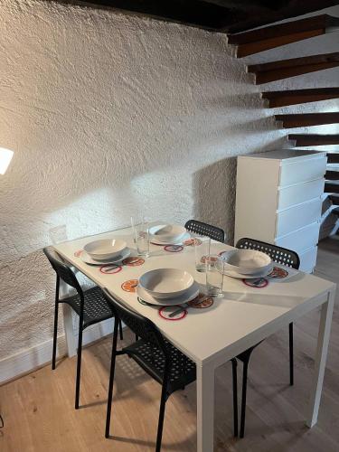 une table blanche avec des chaises et des assiettes dessus dans l'établissement Charmant T3 cœur de ville, à Orléans