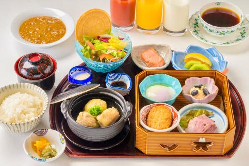 Una mesa con una bandeja de comida y tazones de comida. en Hotel Kitano Plaza Rokkoso, en Kobe