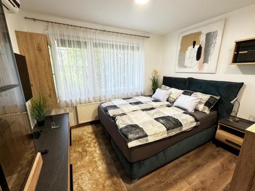 a bedroom with a bed and a window at SZE Business Apartman in Győr