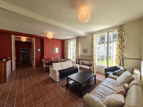un salon avec un canapé et une table dans l'établissement Les Arcades du Chateau, à Versainville