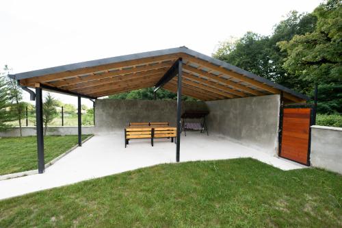 a pavilion with a wooden bench under a roof at Vagabond - Cozy Guesthouse in Lagodekhi in Lagodekhi