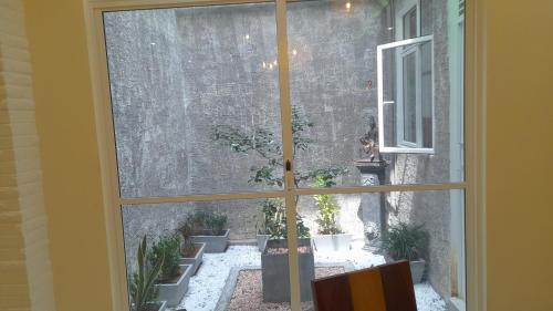 a window view of a courtyard with potted plants at Priyalanka Aprtments in Wadduwa