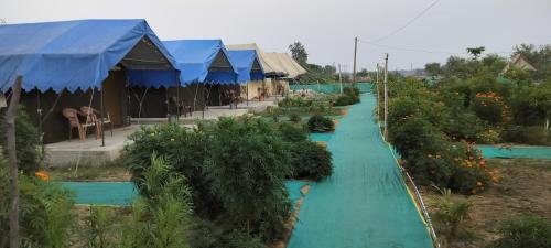 a long blue pathway with trees and plants at Bhitarkanika Eco Resort TENT in Righāgarh