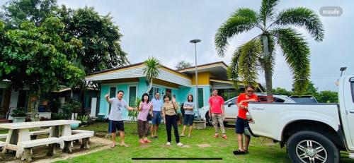 a group of people standing in front of a house at Panutsaya Homestay in Wang Nam Khieo
