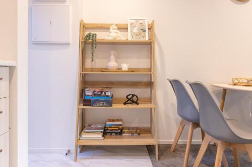 a book shelf in a room with a table and chairs at Entertaining townhouse by Little High Eatery in Christchurch
