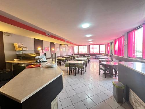 een restaurant met tafels en stoelen en rode gordijnen bij Hotel Battaglia in Battaglia Terme