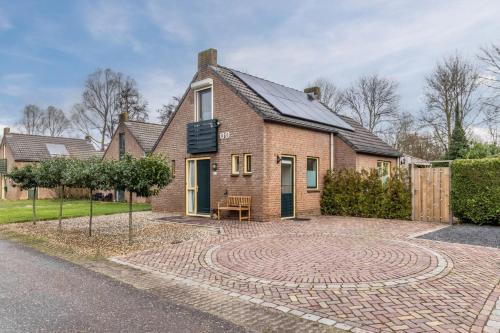 a brick house with a circular driveway at De Eewijkse Hoeve in Ewijk