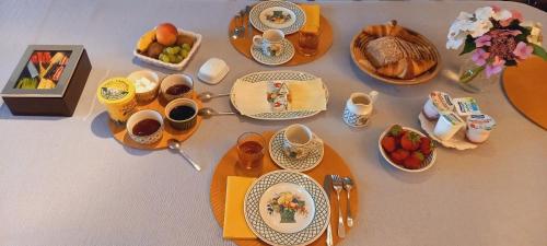 a table with cups and plates of food on it at little cottage in Lasne