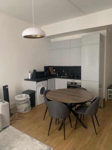 une cuisine avec une table et des chaises dans une pièce dans l'établissement Two-bed apartment - Saint-Lazare, à Paris