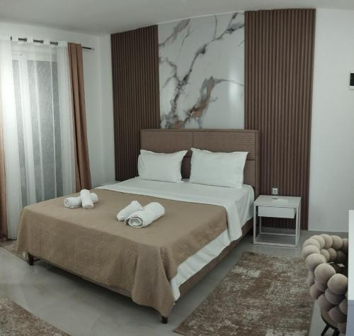 a bedroom with a bed with two towels on it at Kahari Apartments in Ulcinj