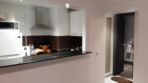 a kitchen with a black counter and a microwave at Le lagon de Hammamet in Hammamet