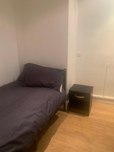 une chambre avec un lit et une table de chevet dans l'établissement Two-bed apartment - Saint-Lazare, à Paris