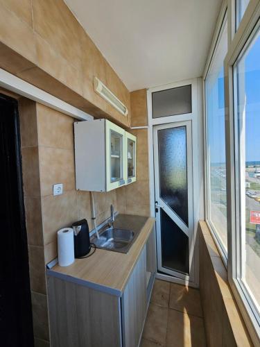 cocina con fregadero y encimera con ventana en Blue Marina Sea View, en Mangalia