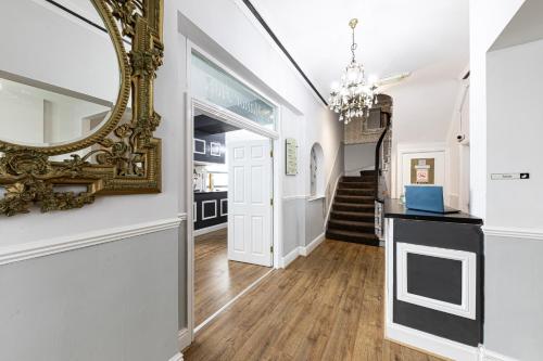 a hallway with a mirror on the wall and a staircase at The Manor Hotel in Llandudno