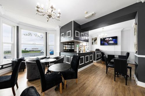 a dining room with black chairs and a table at The Manor Hotel in Llandudno