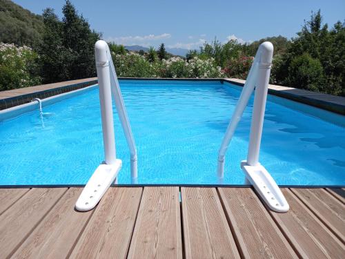 a swimming pool with two metal poles in front of it at L'Alivu in Ajaccio