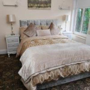 a bedroom with a large bed and a window at Local accommodation for motocycle off-road centres in Swansea