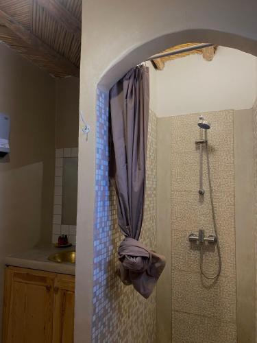 a shower in a bathroom with a shower curtain at Ksar Montana Hôtel, Chambres piscine in Taforhalt
