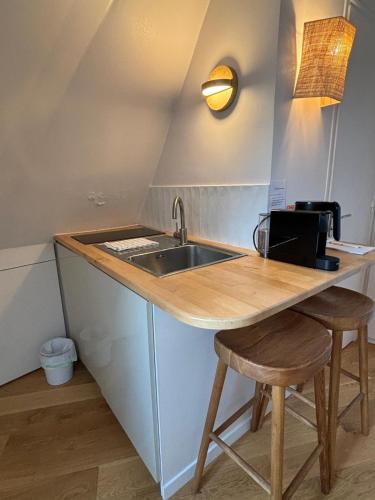 une cuisine avec un évier et un comptoir avec des tabourets dans l'établissement Studio cosy with incredible view, à Paris