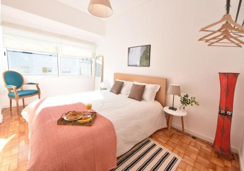 Un dormitorio con una cama con una bandeja de comida. en PinPorto City Center I, en Oporto
