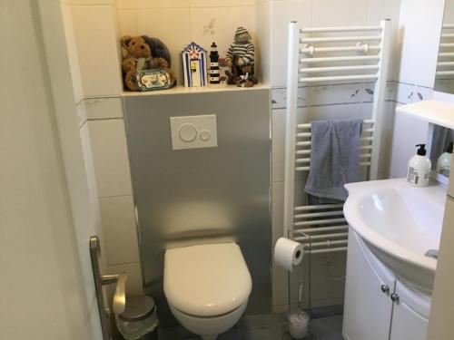 une petite salle de bain avec toilettes et lavabo dans l'établissement Domaine de la coqueraine, à Ouistreham