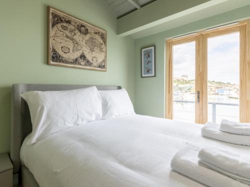 a bedroom with a large white bed with a window at Pass the Keys The Pontoon in Southend-on-Sea