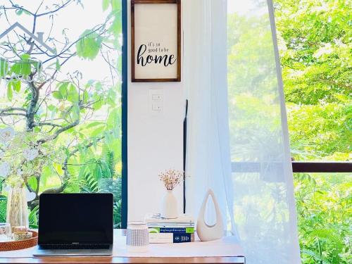 a desk with a laptop computer on it in front of a window at Cloudy Homestay Hoi An in Hoi An