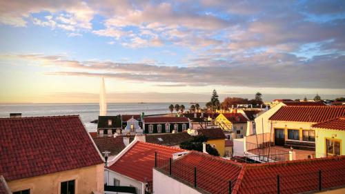 a view of a city with buildings and the ocean at Casa do Mocho Private Room in Lisbon in Paço de Arcos