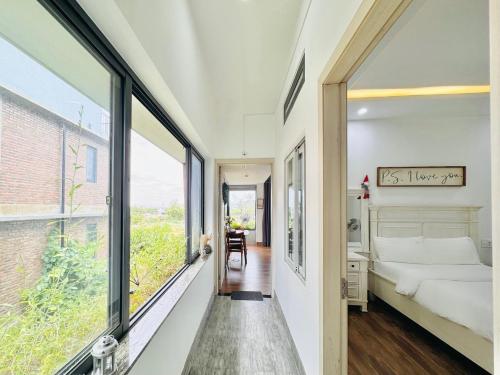 a bedroom with a bed and a large window at Cloudy Homestay Hoi An in Hoi An