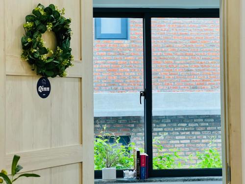 an open door with a window with a brick wall at Cloudy Homestay Hoi An in Hoi An