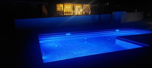 a large swimming pool at night with blue lights at SEA HOUSE mobile home, pool, bikes, SUP - PRIVILEGE POINT camping & villas in Orebić