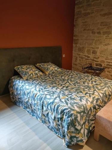 une chambre avec un lit avec une couette dessus dans l'établissement Maison, à Nespouls