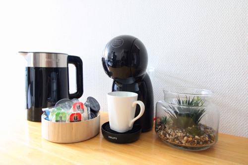 une cafetière assise au-dessus d'une table dans l'établissement Les Jours Calmes, studio chaleureux, à Limoges