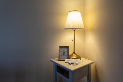 a table with a lamp and a picture on it at La Mansarda del Viandante in Castelbelforte