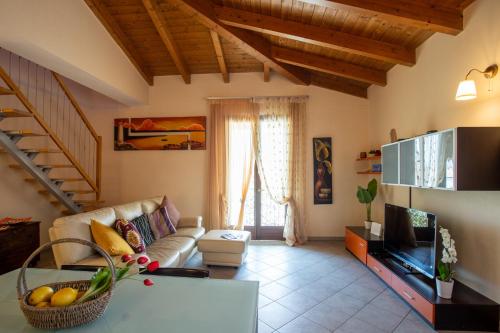 a living room with a couch and a tv at La Mansarda del Viandante in Castelbelforte