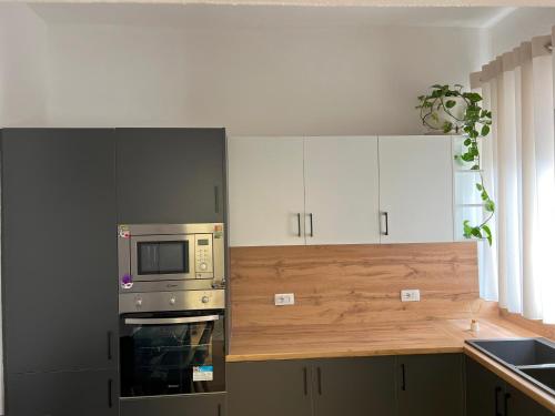 a kitchen with a stove and a microwave at Durres Vintage Apartment in Durrës