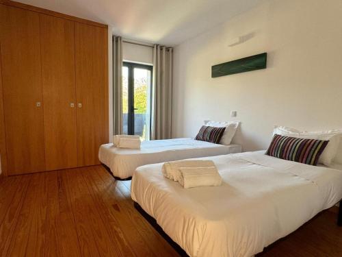 a bedroom with two beds and a window at Quinta Vale da Prata in Celorico da Beira