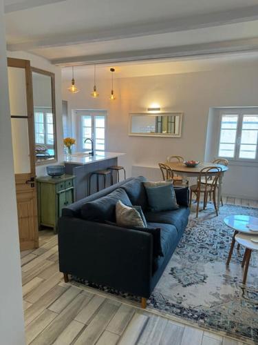 un salon avec un canapé bleu et une cuisine dans l'établissement ARAZY - Superb duplex old Antibes very central, AC, terrace, à Antibes