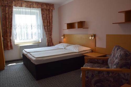 a small bedroom with a bed and a window at Penzion Bohemia in Lomnice nad Lužnicí