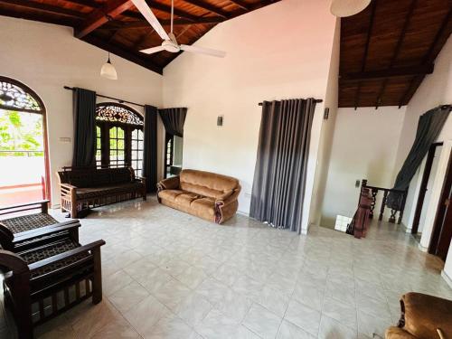a living room with a couch and a piano at Hidden Heaven Villa in Beruwala
