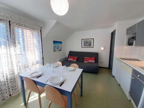 une cuisine et un salon avec une table et des chaises dans l'établissement Studio cosy 4 pers avec balcon, parking et salle de musculation à St Lary Soulan - FR-1-457-270, à Saint-Lary-Soulan