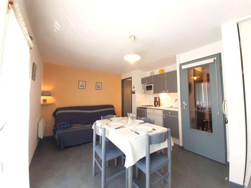 Cette chambre dispose d'une table, d'une cuisine et d'un canapé. dans l'établissement Studio cosy avec balcon, parking, salle de musculation - 4 personnes à Saint-Lary-Soulan - FR-1-457-248, à Saint-Lary-Soulan